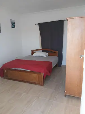 a bedroom with a wooden bed with a red blanket at Cozy Villa in Hurghada