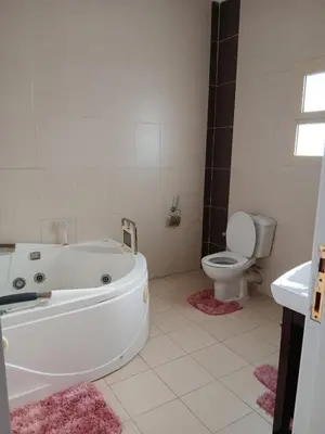 a bathroom with a white tub and a toilet at Cozy Villa in Hurghada
