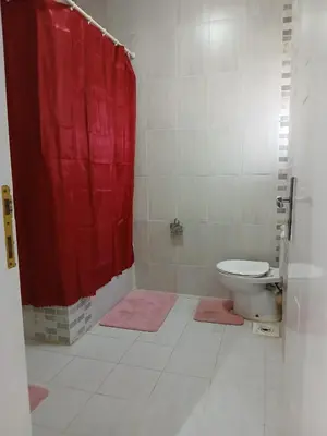 a bathroom with a red shower curtain and a toilet at Cozy Villa in Hurghada