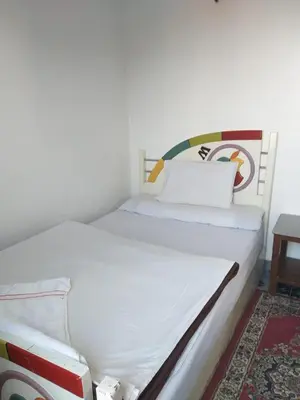 a white bed in a room with at Ziggy Marley Backpackers Hostel in Al Aqālitah