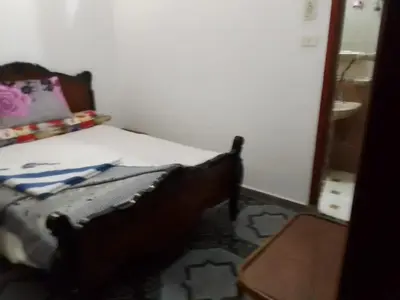 a small bedroom with a bed and a table at Ziggy Marley Backpackers Hostel in Al Aqālitah