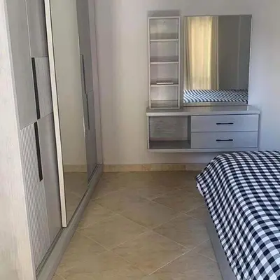 a bedroom with a dresser with a mirror and a bed at West Side B 1 2 in Hurghada