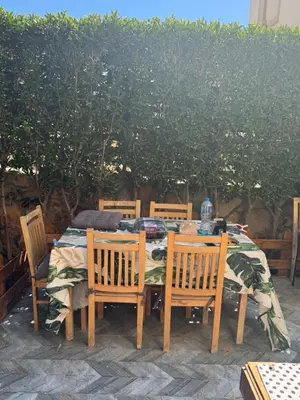 a wooden table with four chairs and a tablecloth on it at The Retreat in Hurghada