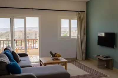 a living room with a couch and a television at Exquisite 2 Bdr Apartment Waterside in Hurghada