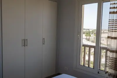 a room with white cabinets and a large window at Exquisite 2 Bdr Apartment Waterside in Hurghada