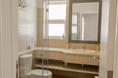 a bathroom with a sink and a toilet and a mirror at Exquisite 2 Bdr Apartment Waterside in Hurghada