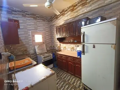 a kitchen with a white refrigerator and wooden cabinets at elqusier redsea in Quseir