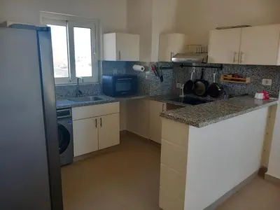 a kitchen with white cabinets and a counter top at Blue Lagoon View - 2 Bed 2 Bath - Shared Pool - El Gouna in Hurghada