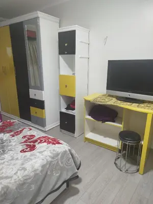 a bedroom with a bed and a desk with a television at Flat in villa San George in Hurghada
