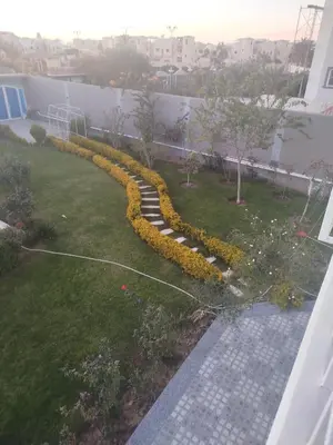 a garden with yellow flowers in a yard at Flat in villa San George in Hurghada