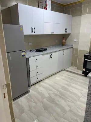 a kitchen with white cabinets and a refrigerator at Aven Resort Compound in Hurghada