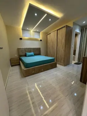 a bedroom with a large bed with a blue blanket at 2 Bedroom in Al Hambra - Mamsha in Hurghada