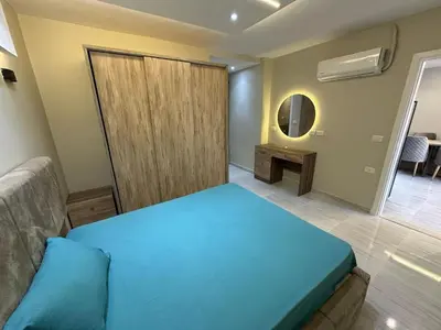 a bedroom with a blue bed and a mirror at 2 Bedroom in Al Hambra - Mamsha in Hurghada
