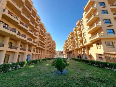 a large apartment building with a tree in the yard at Turtles Beach Resort- Hurghada in Hurghada