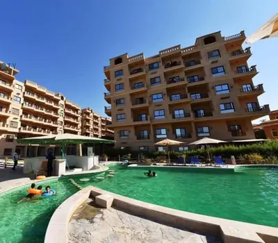 a swimming pool in front of a large building at Turtles Beach Resort- Hurghada in Hurghada
