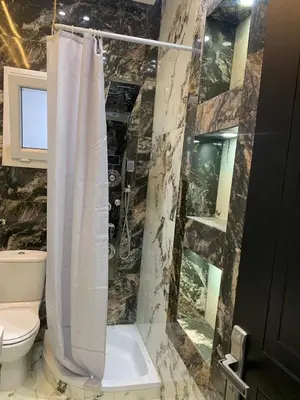 a bathroom with a shower curtain and a toilet at 2 Bedroom in Andreas Residence in Hurghada