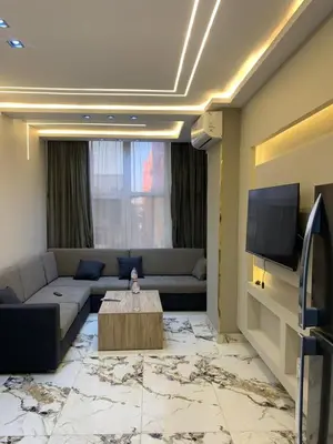 a living room with a couch and a tv at 2 Bedroom in Andreas Residence in Hurghada