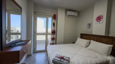 a bedroom with a large white bed with a window at Elite AlDaU Heights in Hurghada
