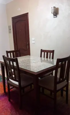 a dining room table with four chairs and a table and a door at الغردقة in Hurghada