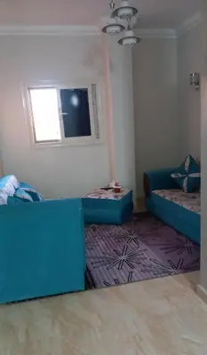 a living room with a blue couch and a window at الغردقة in Hurghada