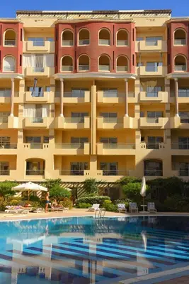 a hotel with a swimming pool in front of a building at Compound floranza in Hurghada
