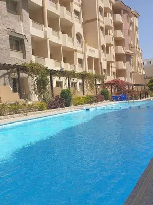 a large blue swimming pool in front of a building at Compound floranza in Hurghada