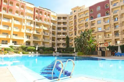 a swimming pool in front of a large building at Compound floranza in Hurghada