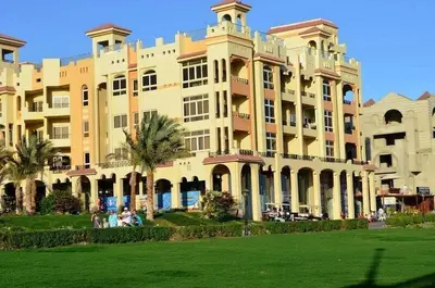 a large building with palm trees in front of it at Sea view Luxury apartment at Al Andalous Sahl Hasheesh in Hurghada