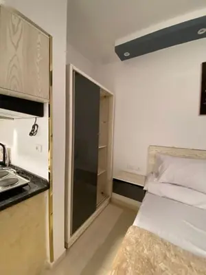 a small room with a bed and a kitchen at شقه فردين مطله علي حمام السباحه في الغردقه in Hurghada