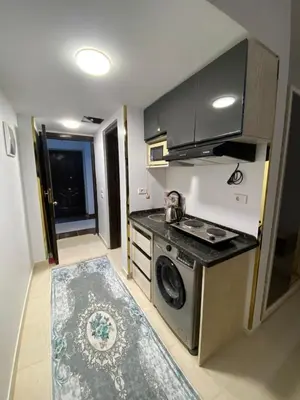 a kitchen with a stove and a washing machine at شقه فردين مطله علي حمام السباحه في الغردقه in Hurghada