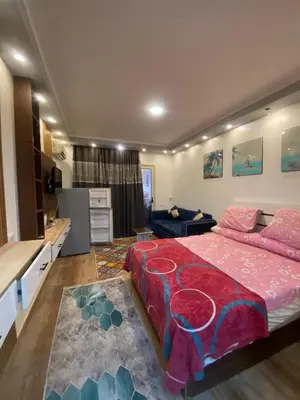 a bedroom with a large bed and a kitchen at شقه فردين مطله علي حمام السباحه في الغردقه in Hurghada