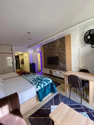 a bedroom with a bed and a desk and a television at شقه فردين مطله علي حمام السباحه في الغردقه in Hurghada
