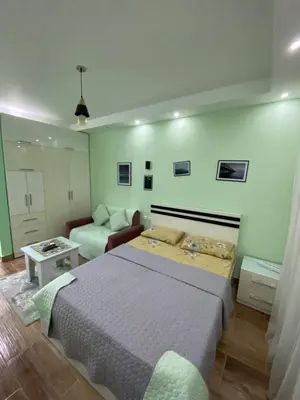 a bedroom with a bed and a living room at شقه فردين مطله علي حمام السباحه في الغردقه in Hurghada