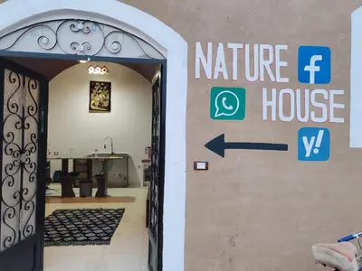 an entrance to a house with a sign on the door at Nature House in Luxor