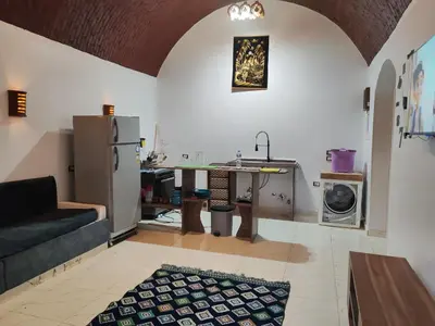 a kitchen and living room with a couch and a refrigerator at Nature House in Luxor