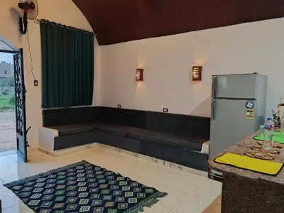 a kitchen with a couch and a refrigerator in it at Nature House in Luxor