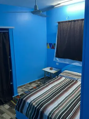 a blue room with a bed and a table at AnDy Nubian Guest House in Aswan