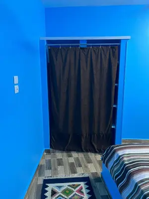 a blue room with a bed and a window at AnDy Nubian Guest House in Aswan