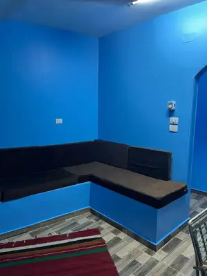 a couch in a room with a blue wall at AnDy Nubian Guest House in Aswan