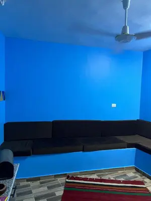 a living room with a blue wall and a couch at AnDy Nubian Guest House in Aswan