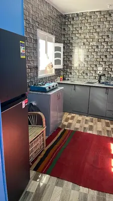 a kitchen with a counter and a kitchen with a rug at AnDy Nubian Guest House in Aswan