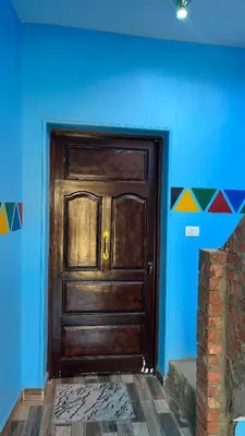 a wooden door in a room with a blue wall at AnDy Nubian Guest House in Aswan