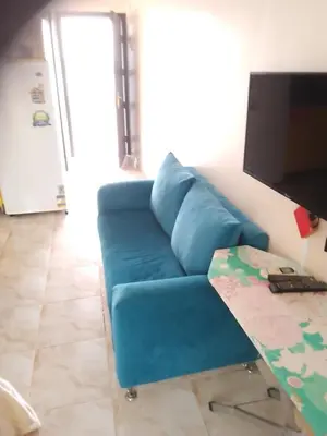a blue couch in a living room with a table at Studio on the roof in Hurghada