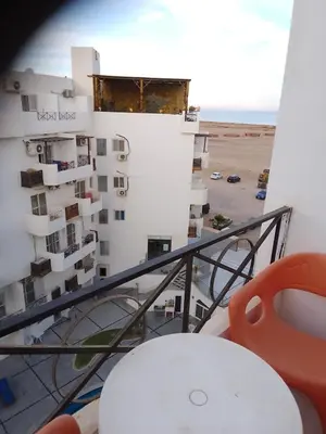 a balcony with a table and a building at Studio on the roof in Hurghada
