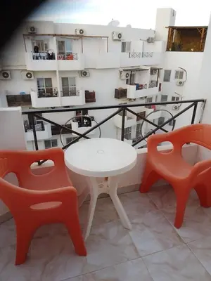 a table and two chairs in front of a balcony at Studio on the roof in Hurghada