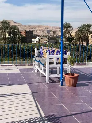 a white bench with pillows on it on a patio at Roses House Ladies & families only in Luxor