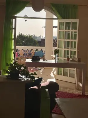 a living room with a table and a large window at Roses House Ladies & families only in Luxor