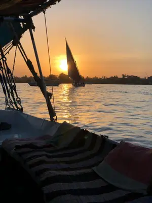 a boat in the water with the sunset in the background at luxor in Luxor