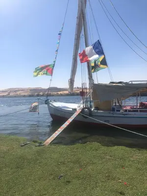 a boat with flags on it sitting in the water at luxor in Luxor