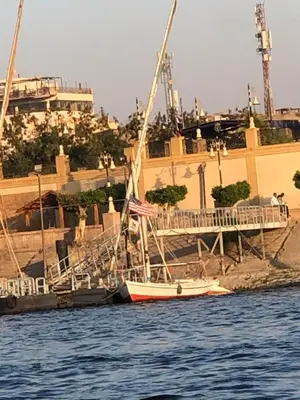 a small boat in the water in front of a building at luxor in Luxor